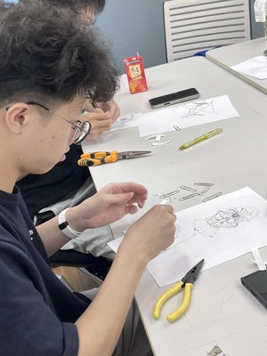 學生專注的將迴紋針化成材料創作小組Logo圖片