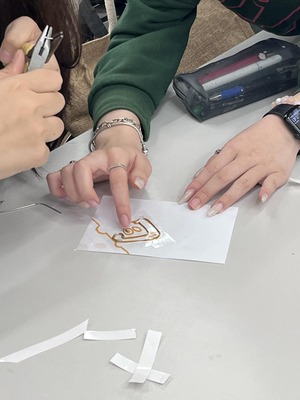 學生專注迴紋針與LED的製作手部特寫，展示實作過程圖片