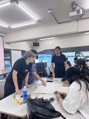 學生小組圍繞底板討論設計的場景，呈現團隊協作氛圍圖片