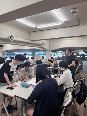 學生小組圍繞底板討論設計的場景，呈現團隊協作氛圍圖片